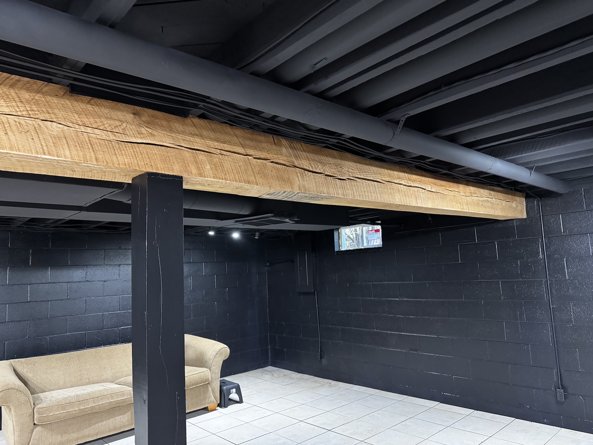 Basement with painted block and a wood beam