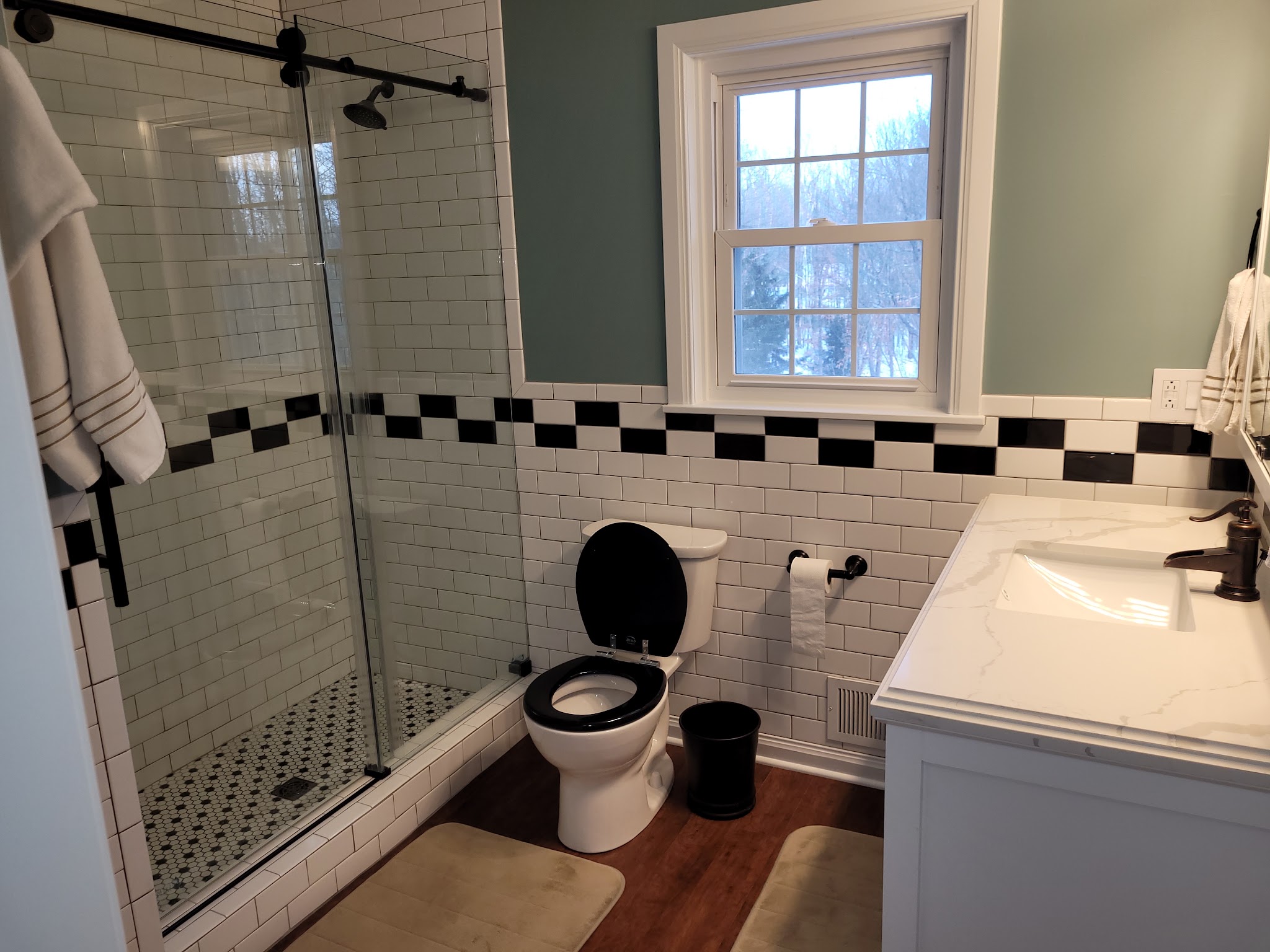 Finished bathroom with subway tile and glass shower door